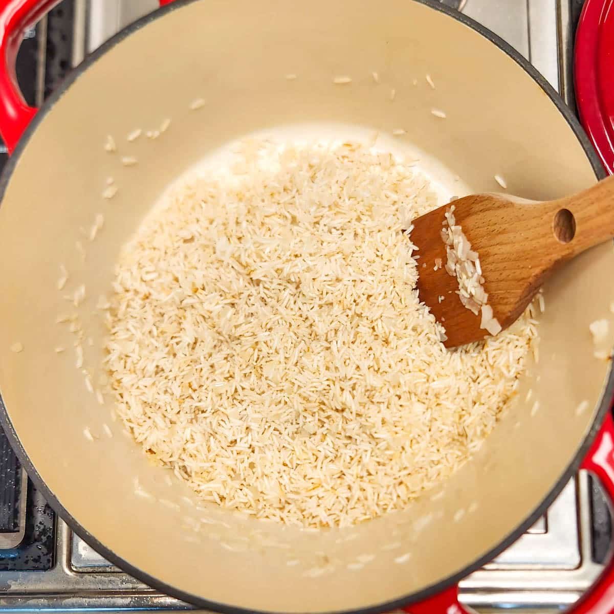 rice that is being toasted in a pot 