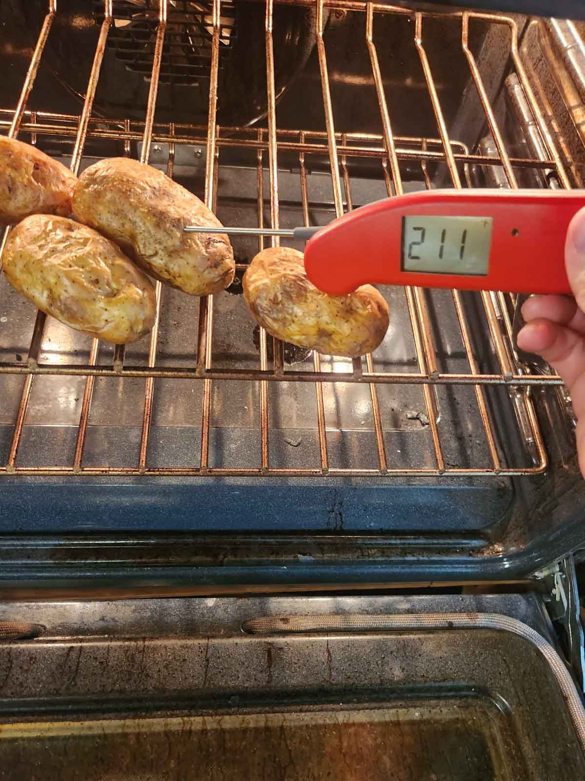 checking the temp of a baked potato with an instant read thermometer