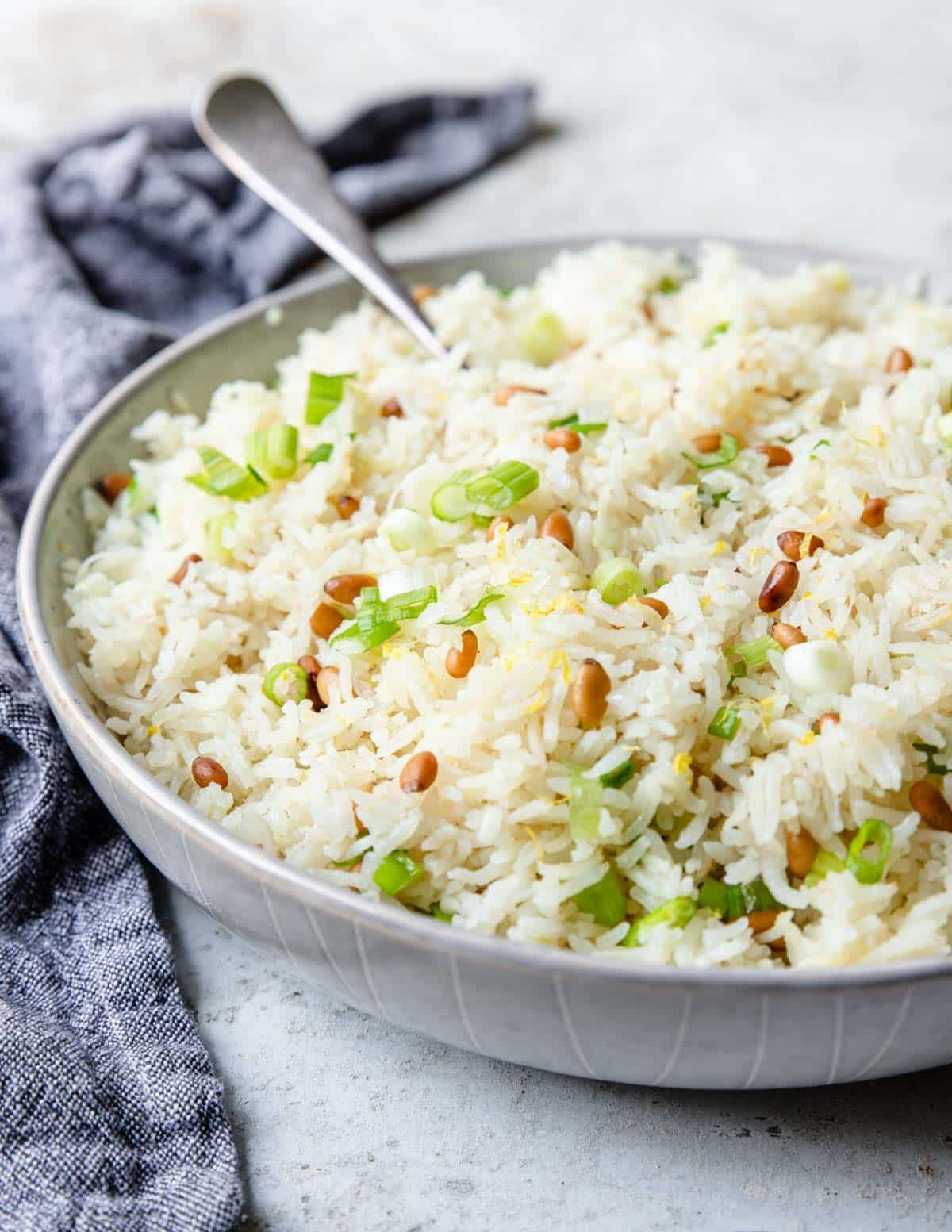 a large bowl of rice pilaf with a spoon and a napkin