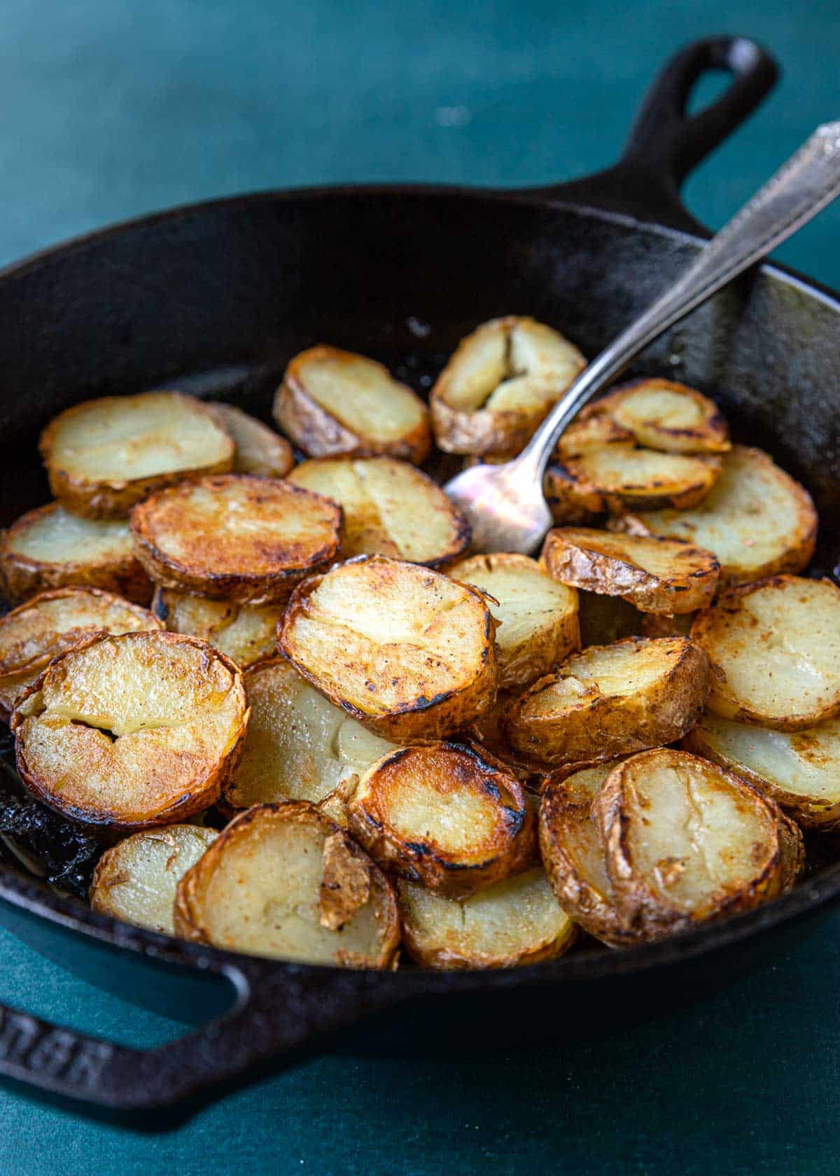 cast iron skillet with sliced leftover baked potatoes 