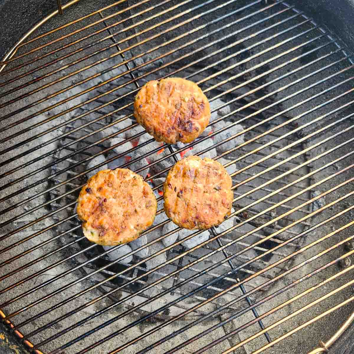 three salmon burgers on the grill