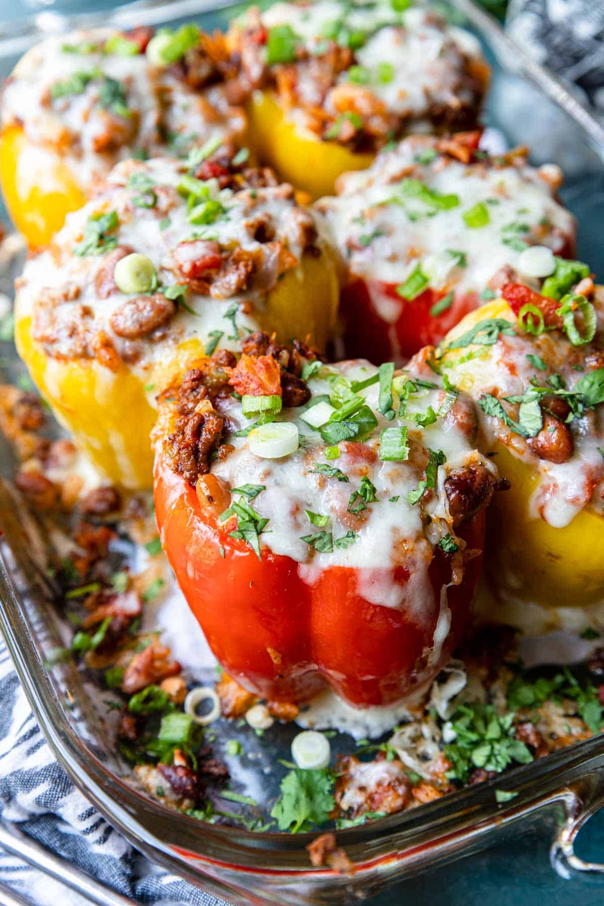 stuffed peppers in a casserole pan, topped with melted with cheese