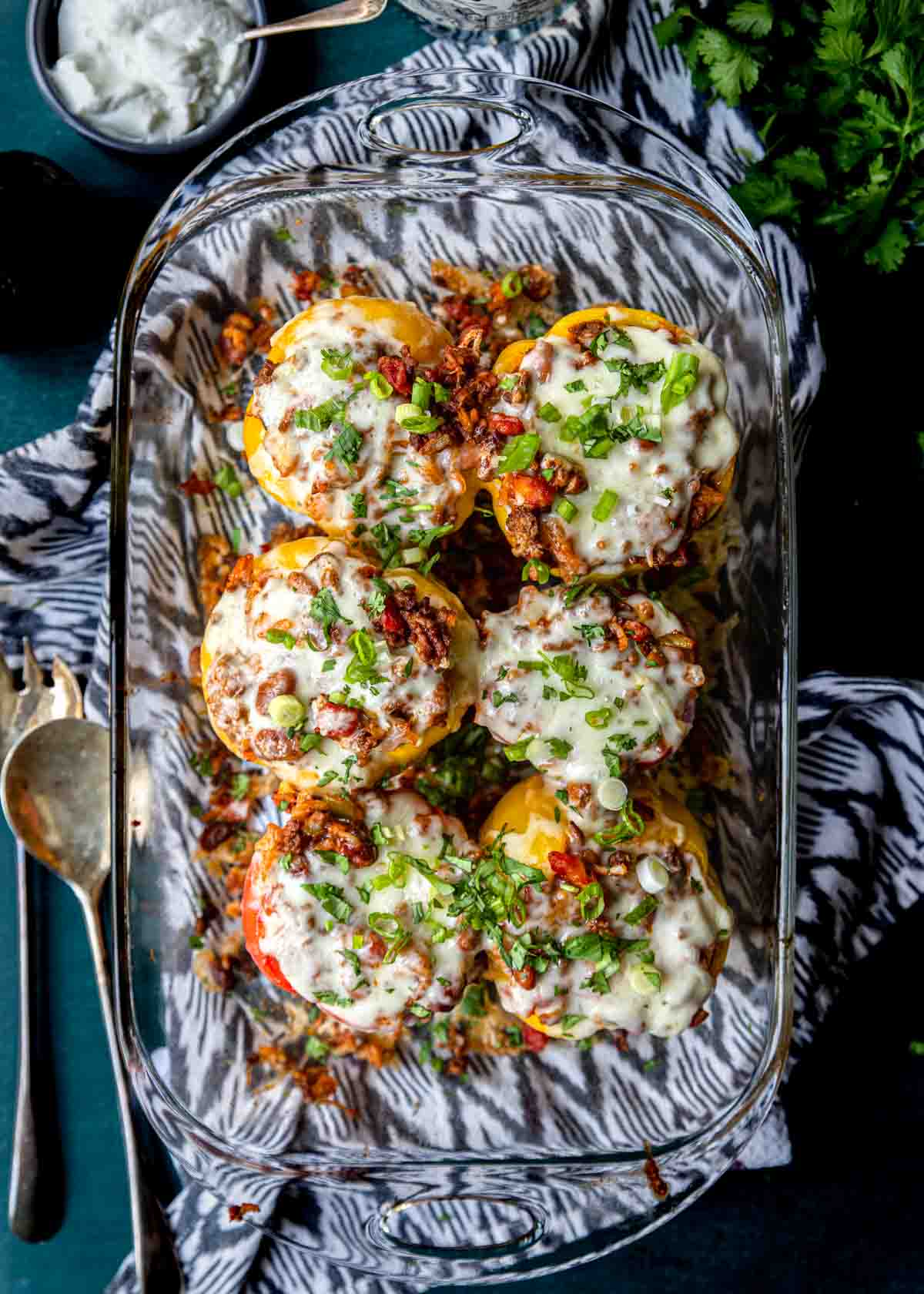 a 9x13 pan full of stuffed bell peppers topped with melted cheese 