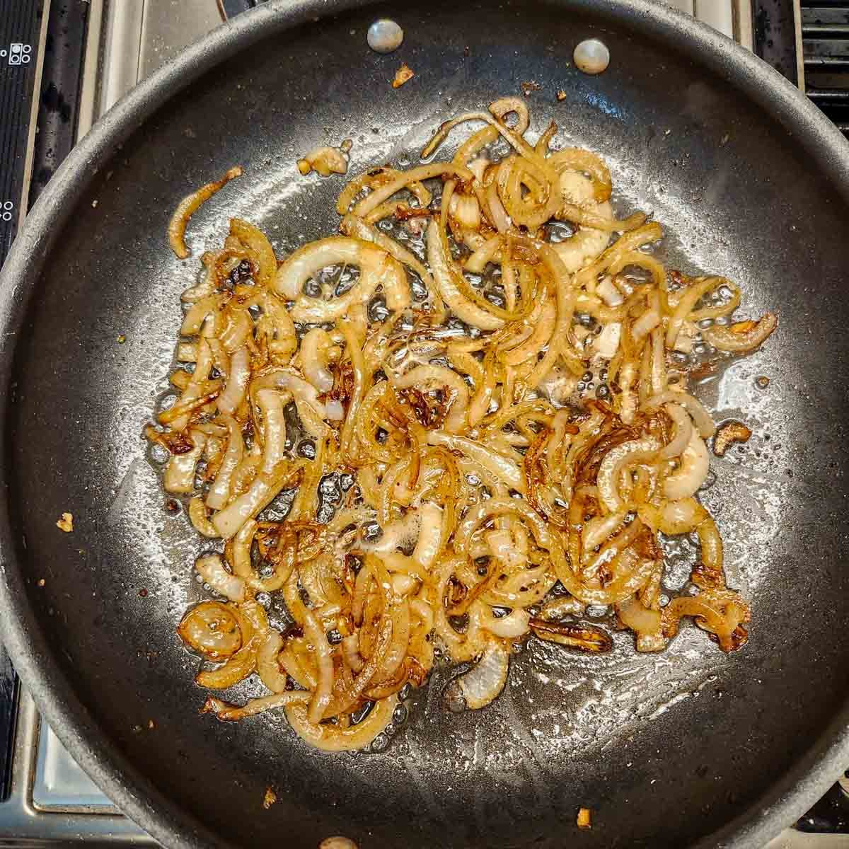 onions being caramelized in a skillet 