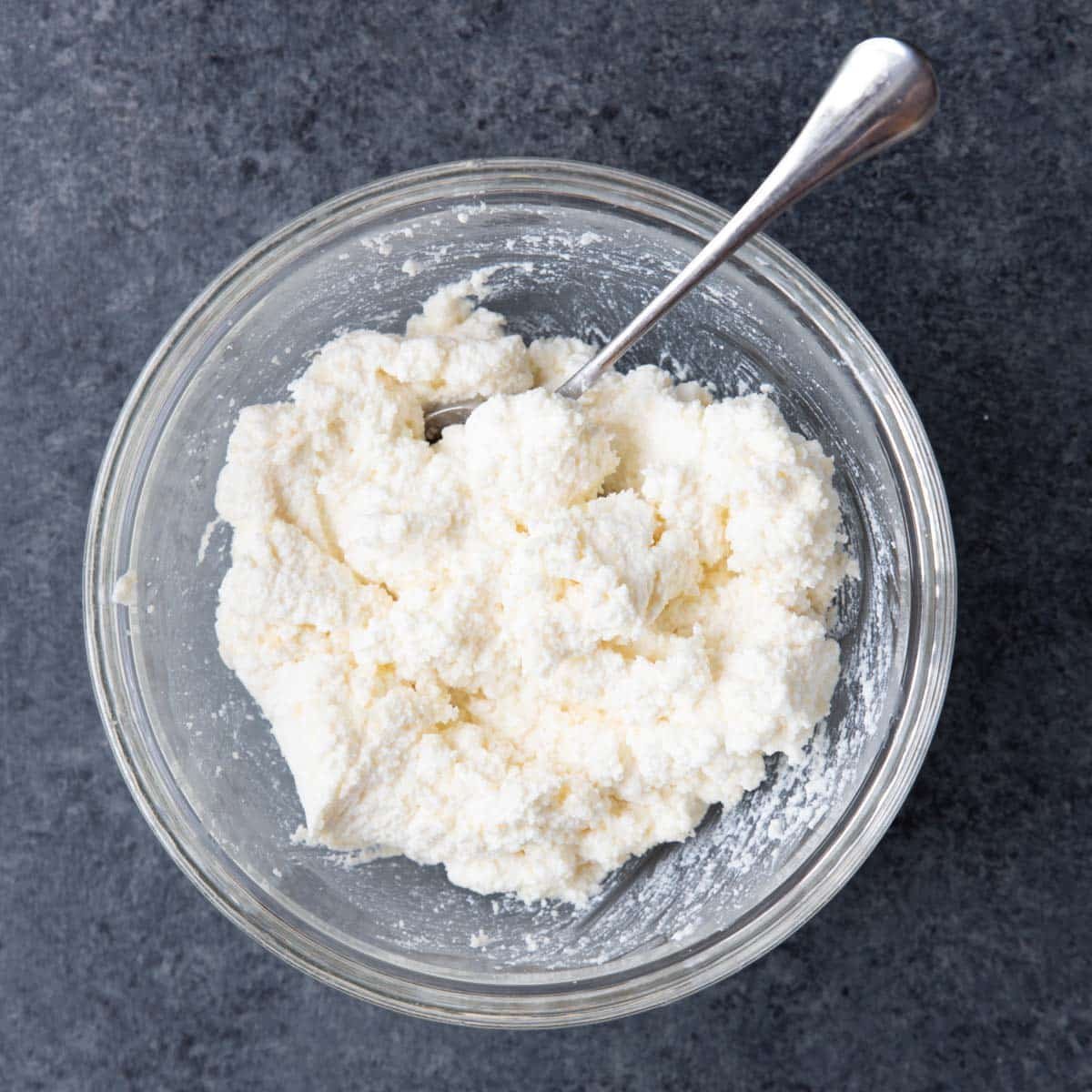 a bowl of ricotta cheese mixed with parmesan cheese