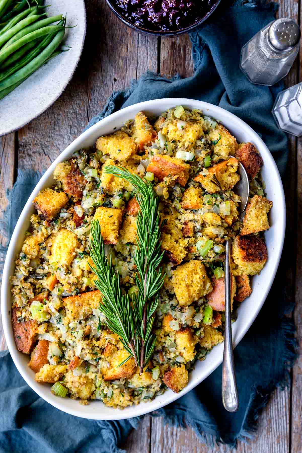 cornbread stuffing in an oval casserole pan with rosemary on top