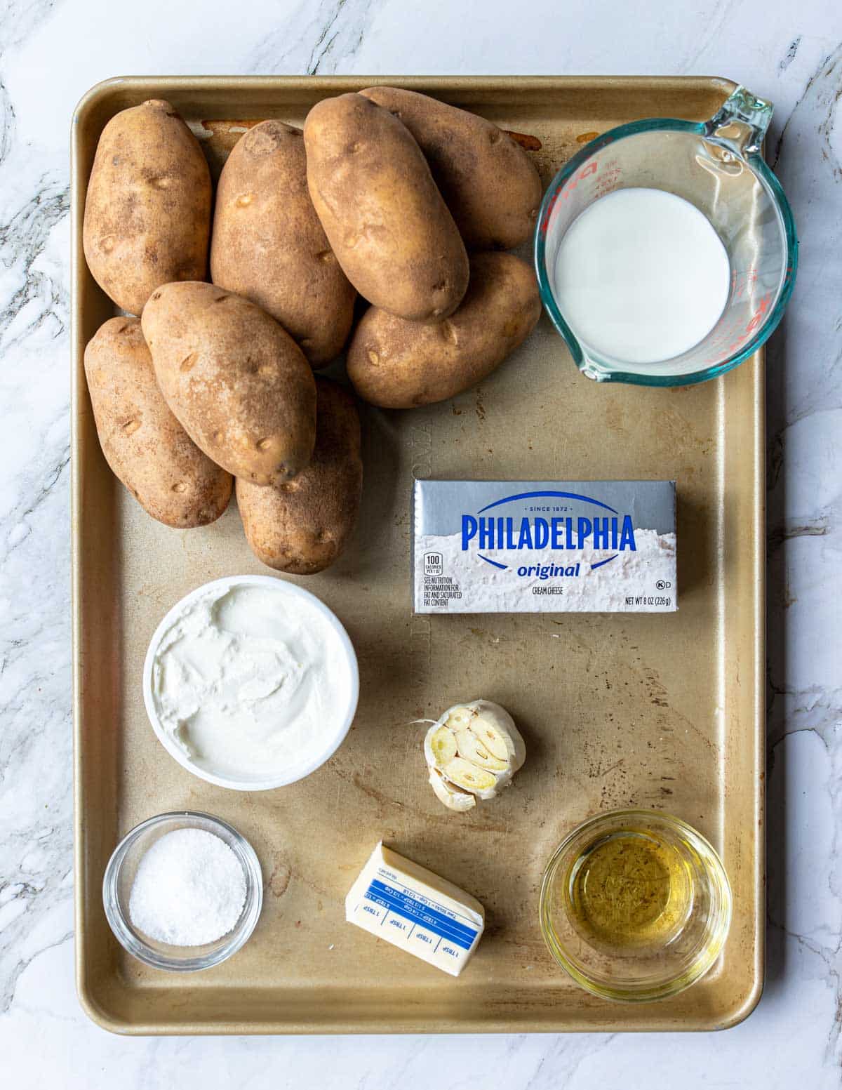 ingredients for roasted garlic mashed potatoes on a sheet pan