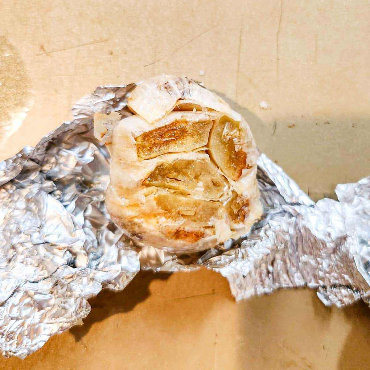 roasted garlic being pulled from some foil