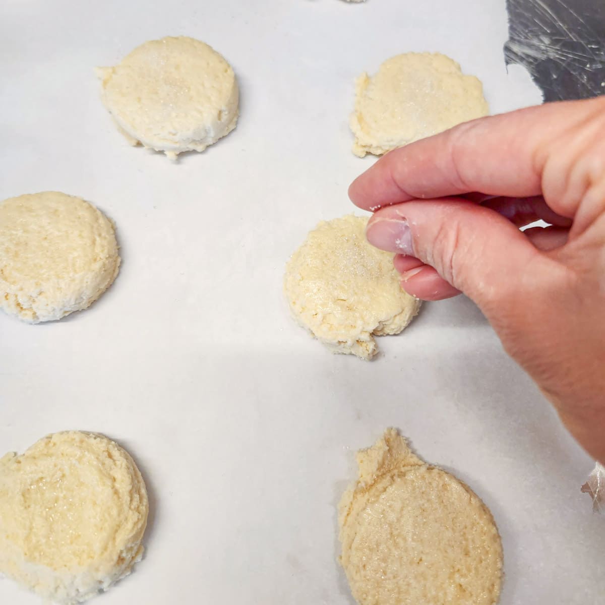 sprinkling sugar on top of sugar cookie dough