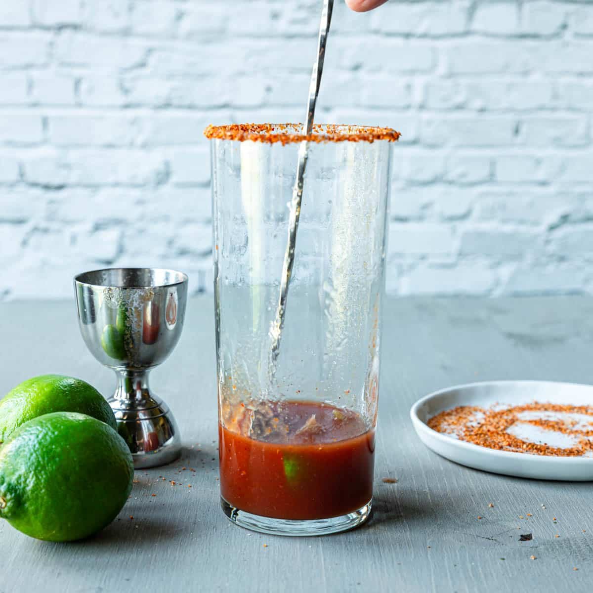 stirring the tomato and spices for a Michelada