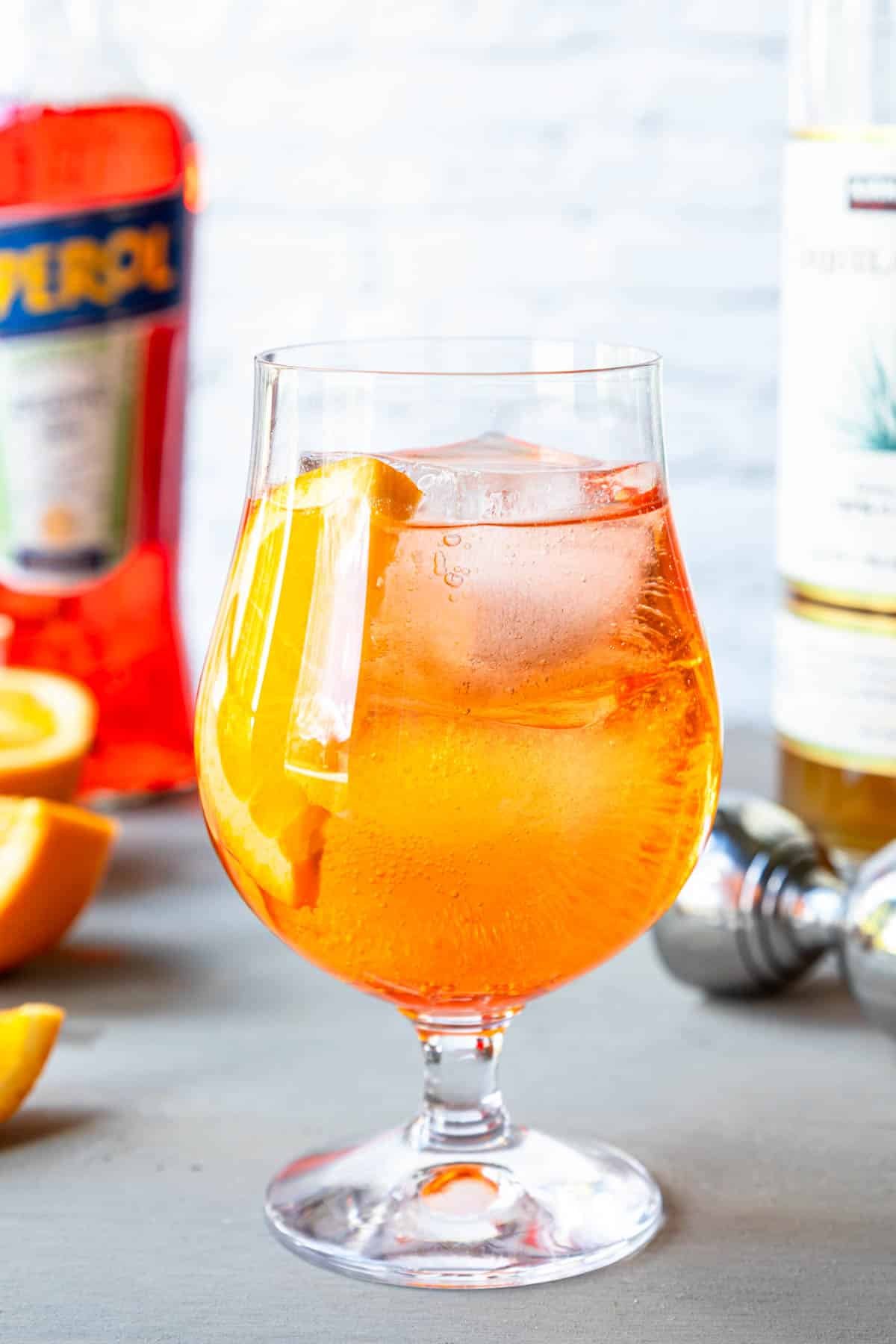 Aperol Tequila Spritz in a stemmed glass with an orange slice 