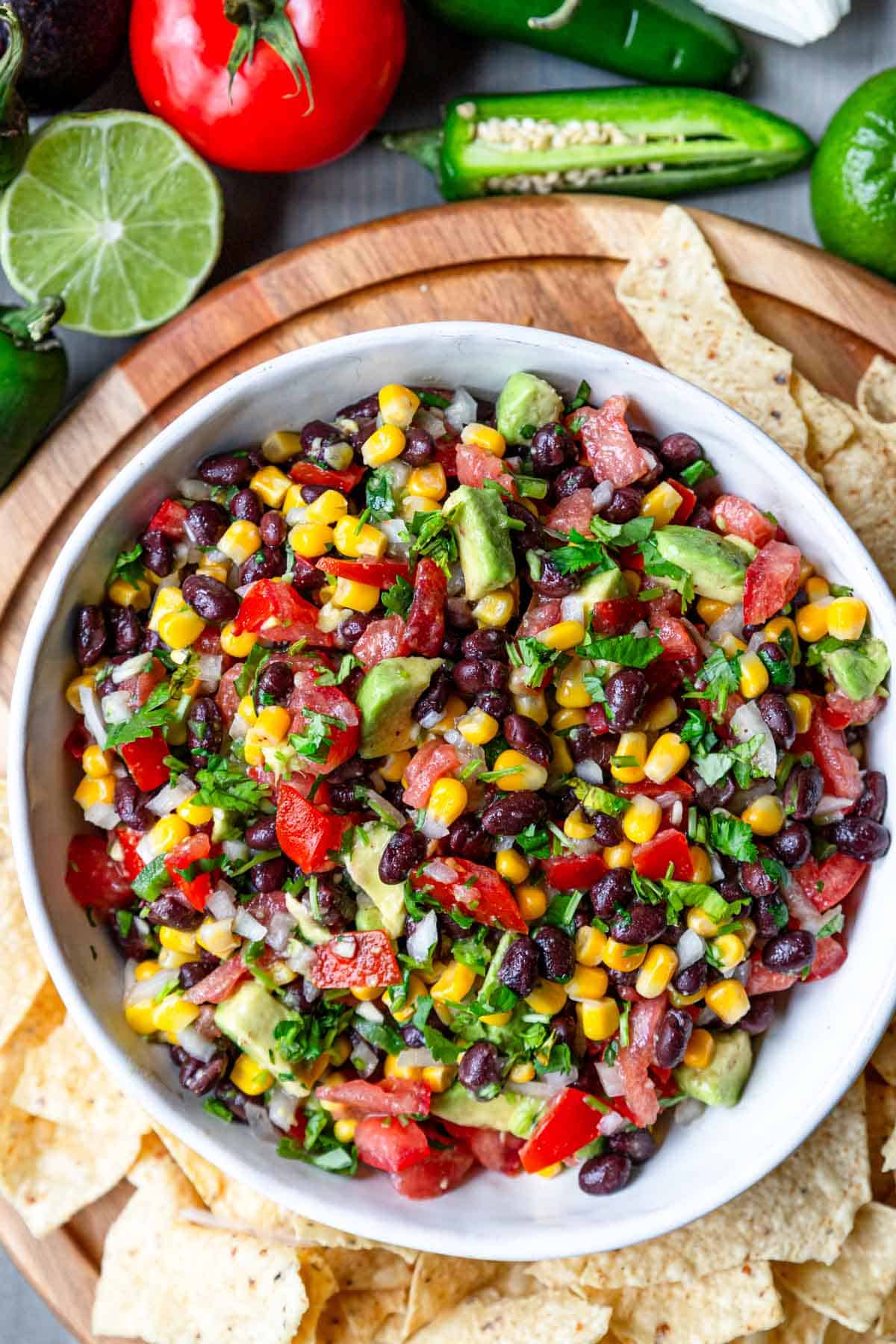 a white bowl filled with black bean salsa and tortilla chips 