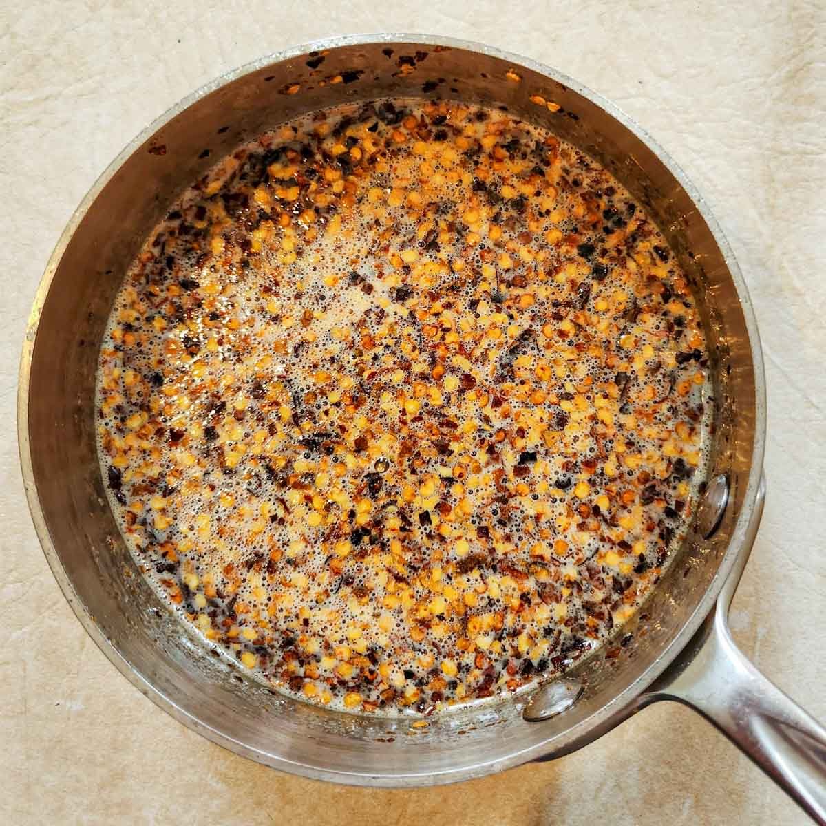 honey and red pepper flakes steeping in a pot to make hot honey