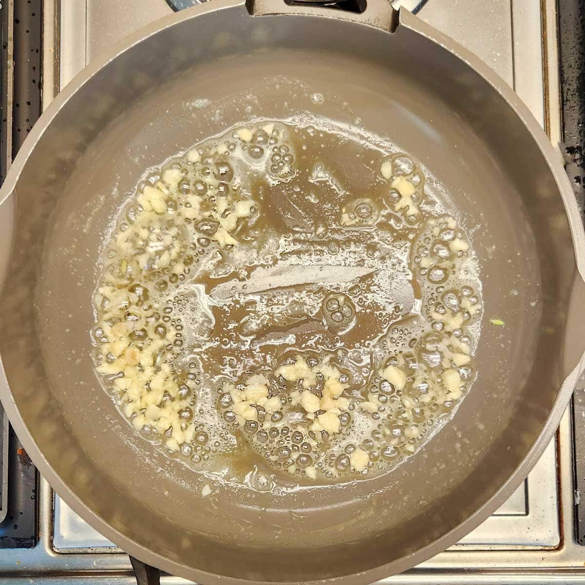 a skillet with garlic, shrimp and butter