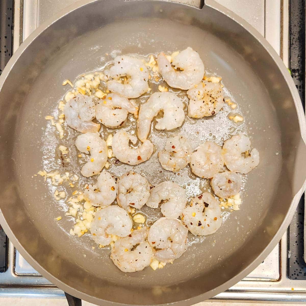a skillet with garlic, shrimp and butter
