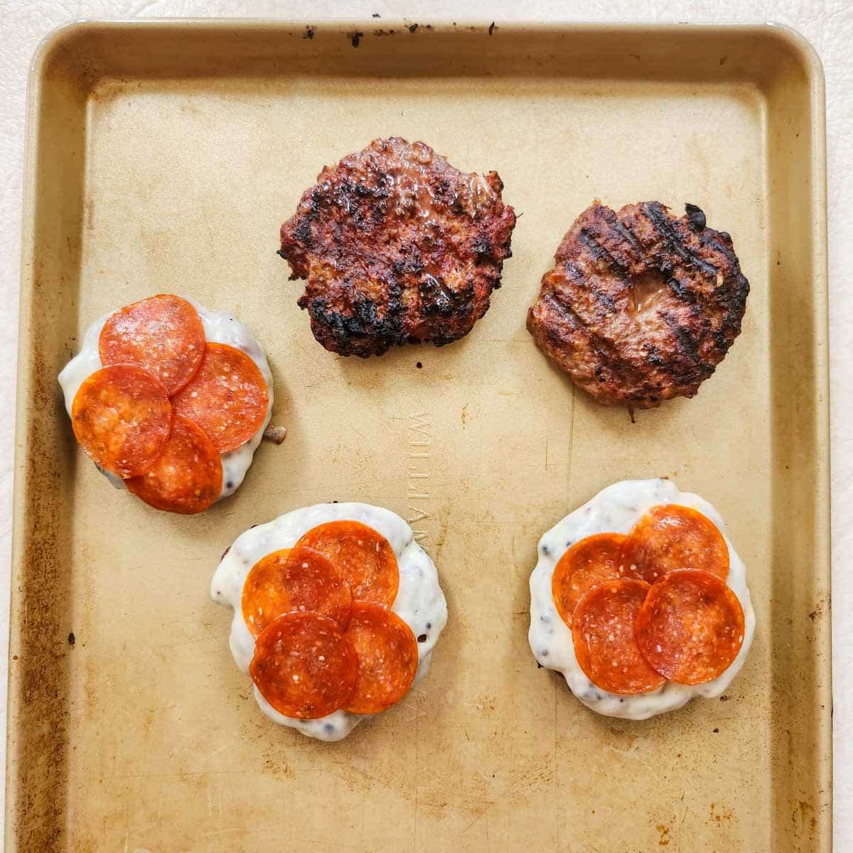 pizza burgers that have been grilled, some have cheese and pepperoni on top