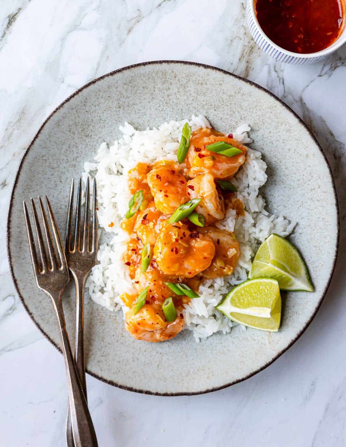 Ginger Garlic Shrimp on a plate with rice and lime wedges