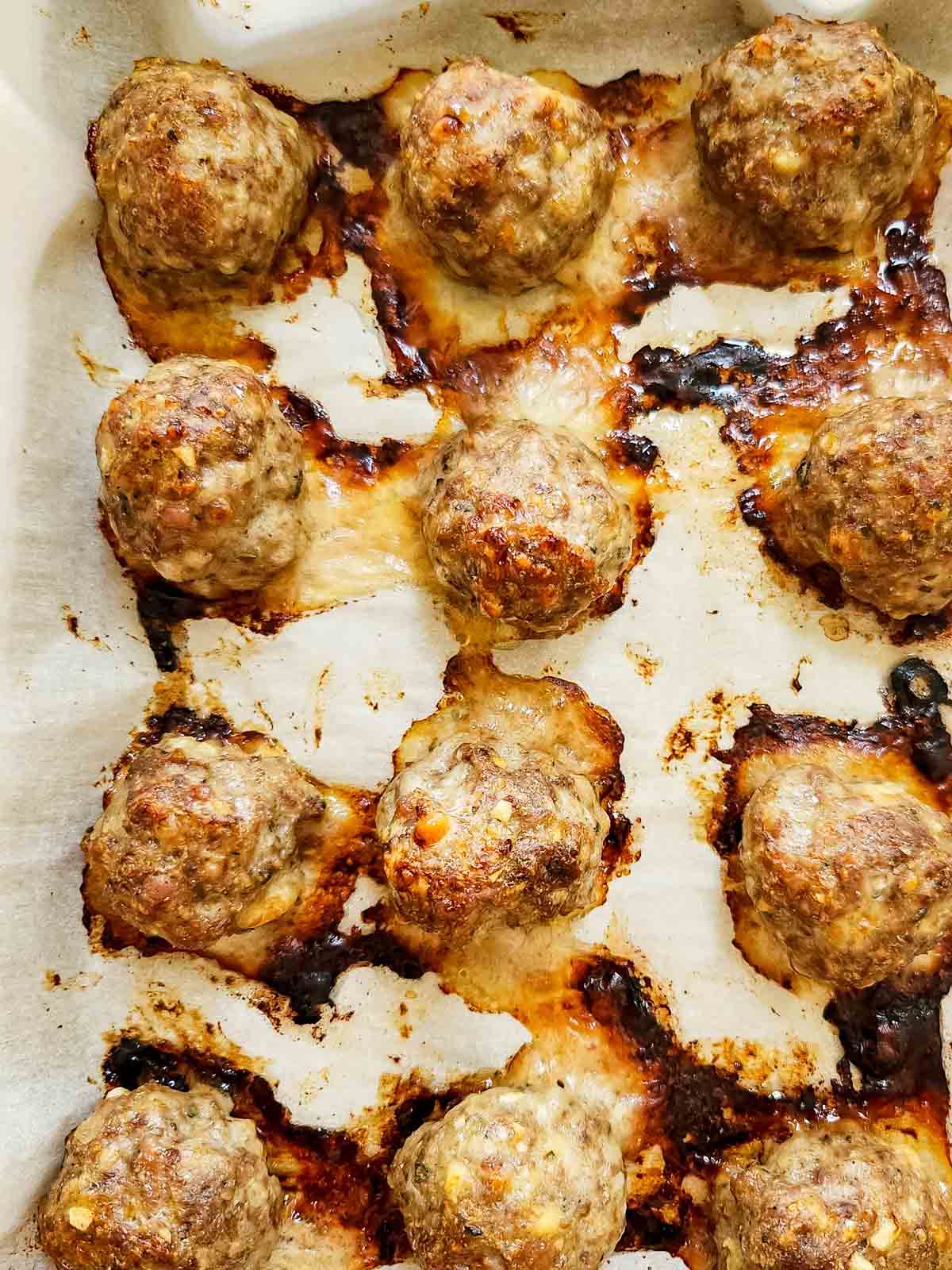 baked Italian Sausage Meatballs on a baking sheet with parchment paper 
