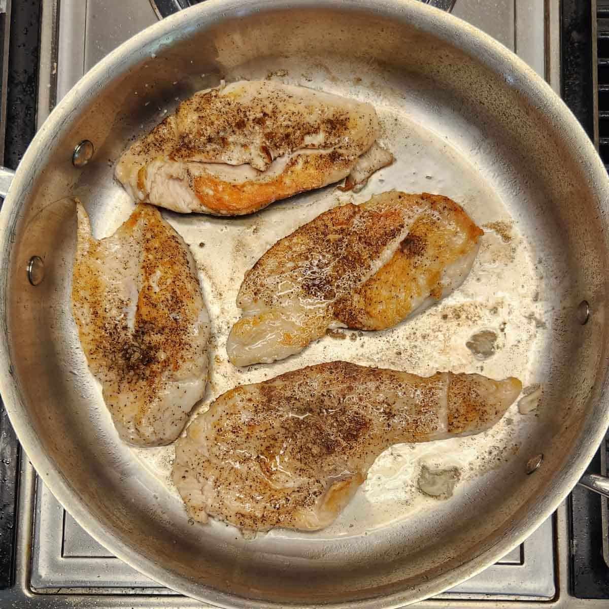 chicken breasts cooked in a pan