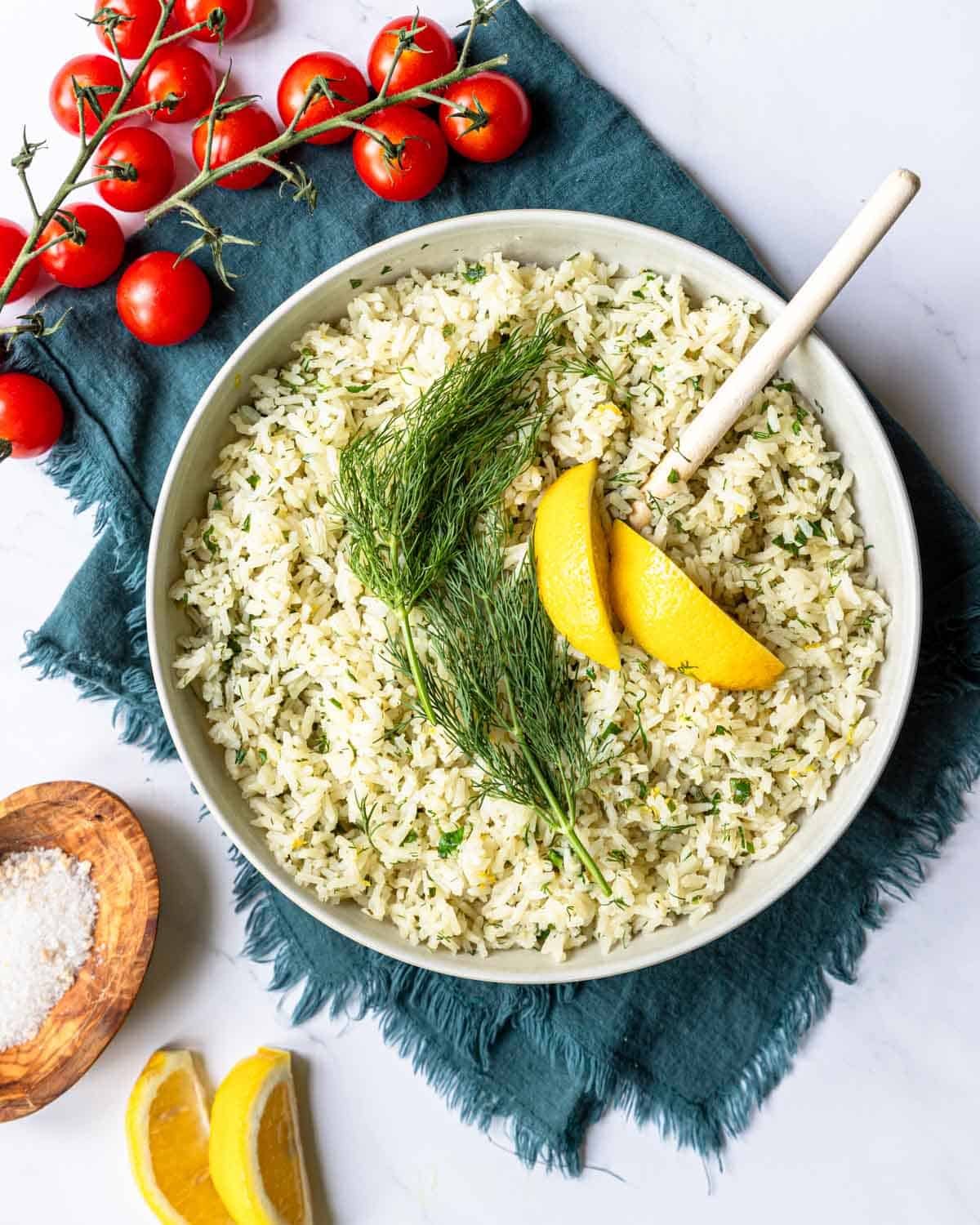 a bowl with lemon rice topped with dill and fresh lemon slices