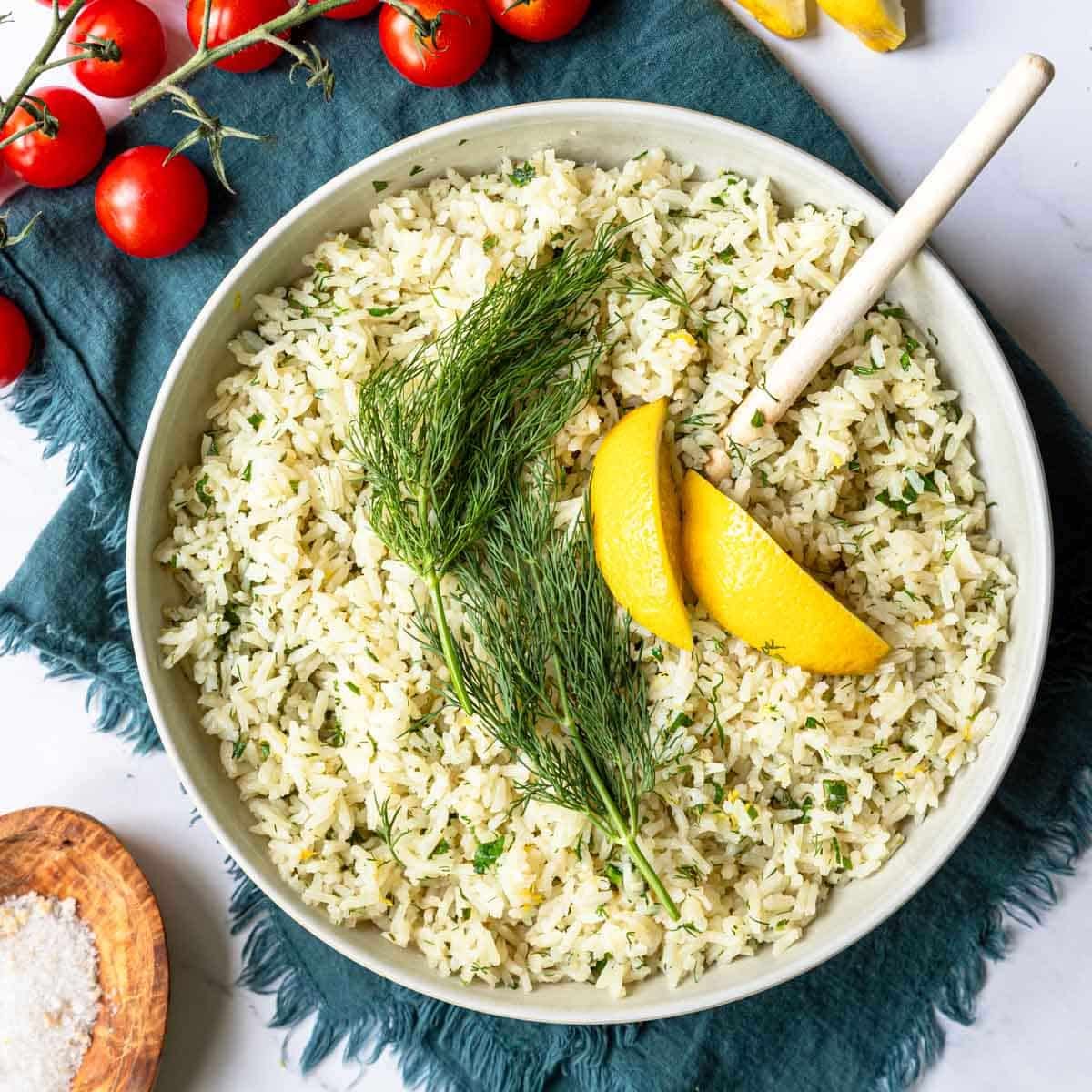 a bowl of lemon rice pilaf with dill and lemon on top