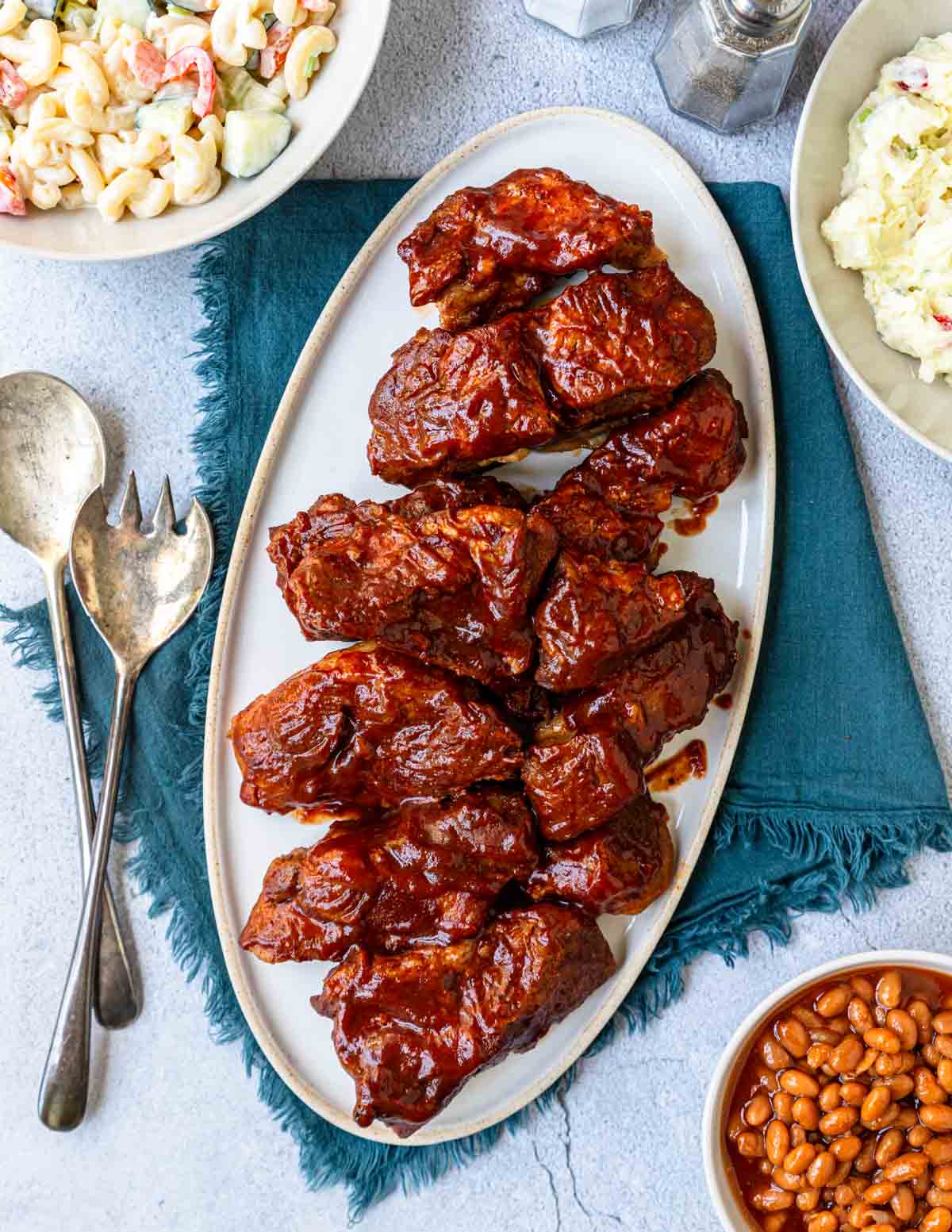 a platter of country style ribs with side dishes around 