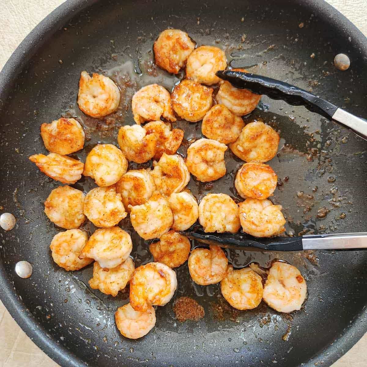 sauteed shrimp in a skillet coated in a glaze