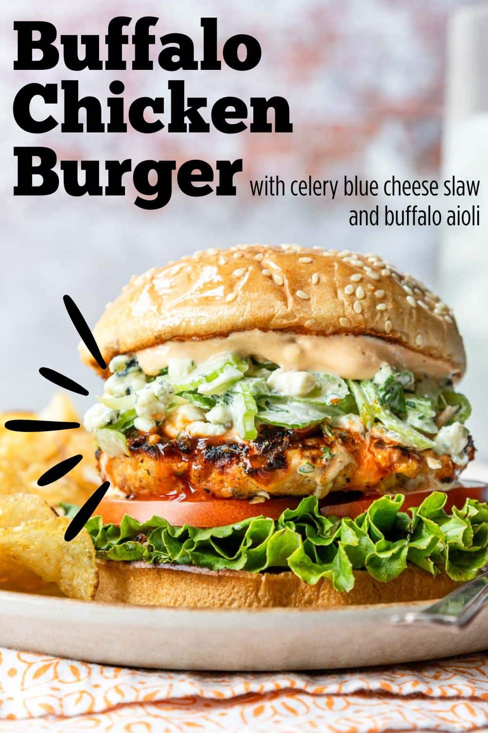 Pinterest pin for Buffalo chicken burger on a sesame seed bun with a celery blue cheese slaw and buffalo aioli served over it.