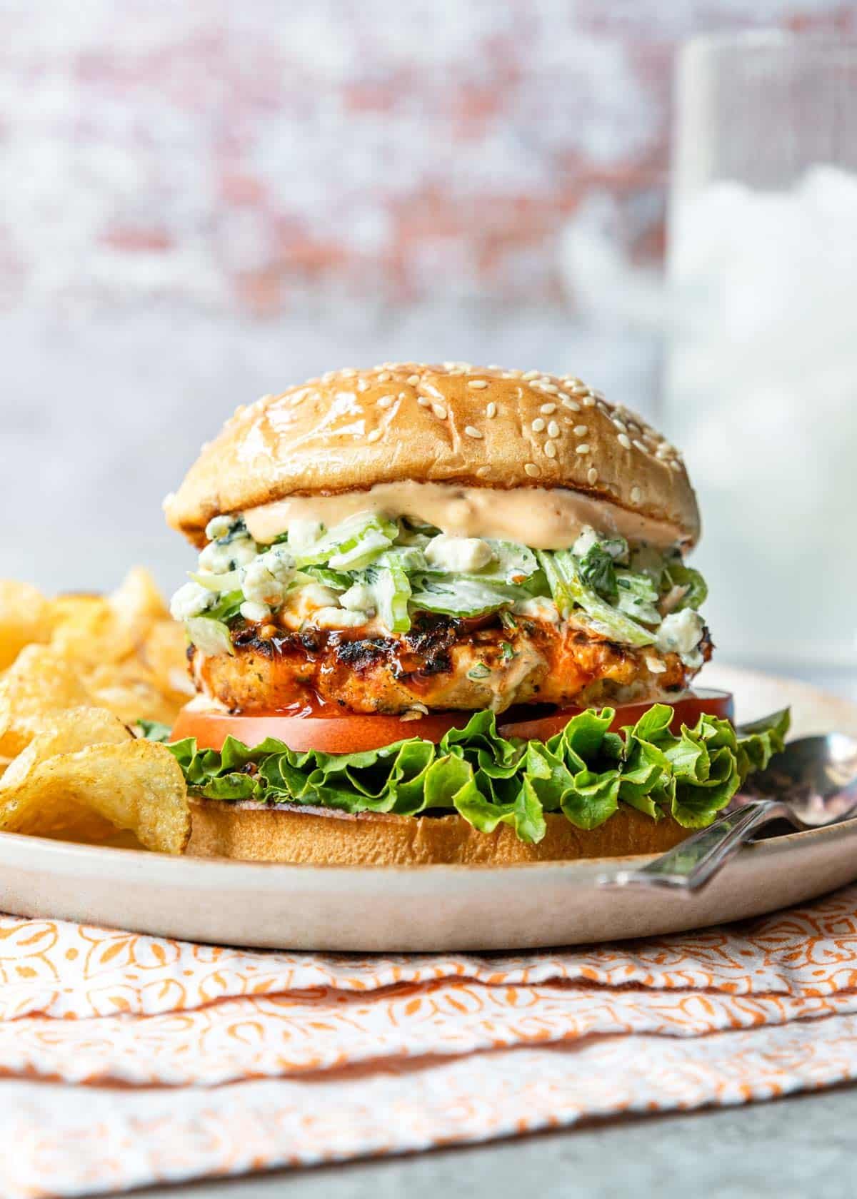 Buffalo chicken burger on a sesame seed bun with buffalo aioli and celery blue cheese slaw.