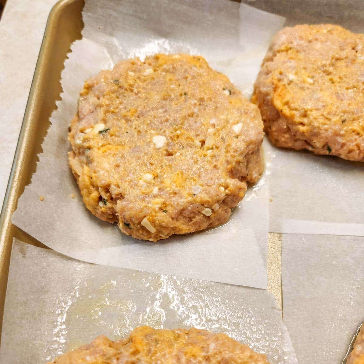 Buffalo burger mixture in burger shape resting on parchment paper.