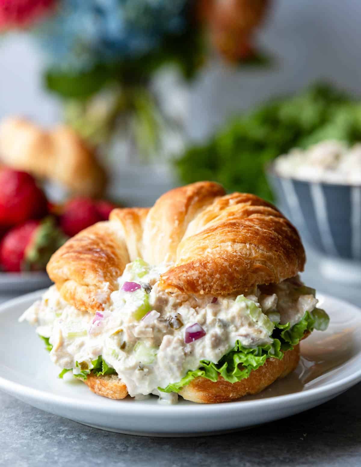 Tuna salad on a croissant with lettuce and tomato