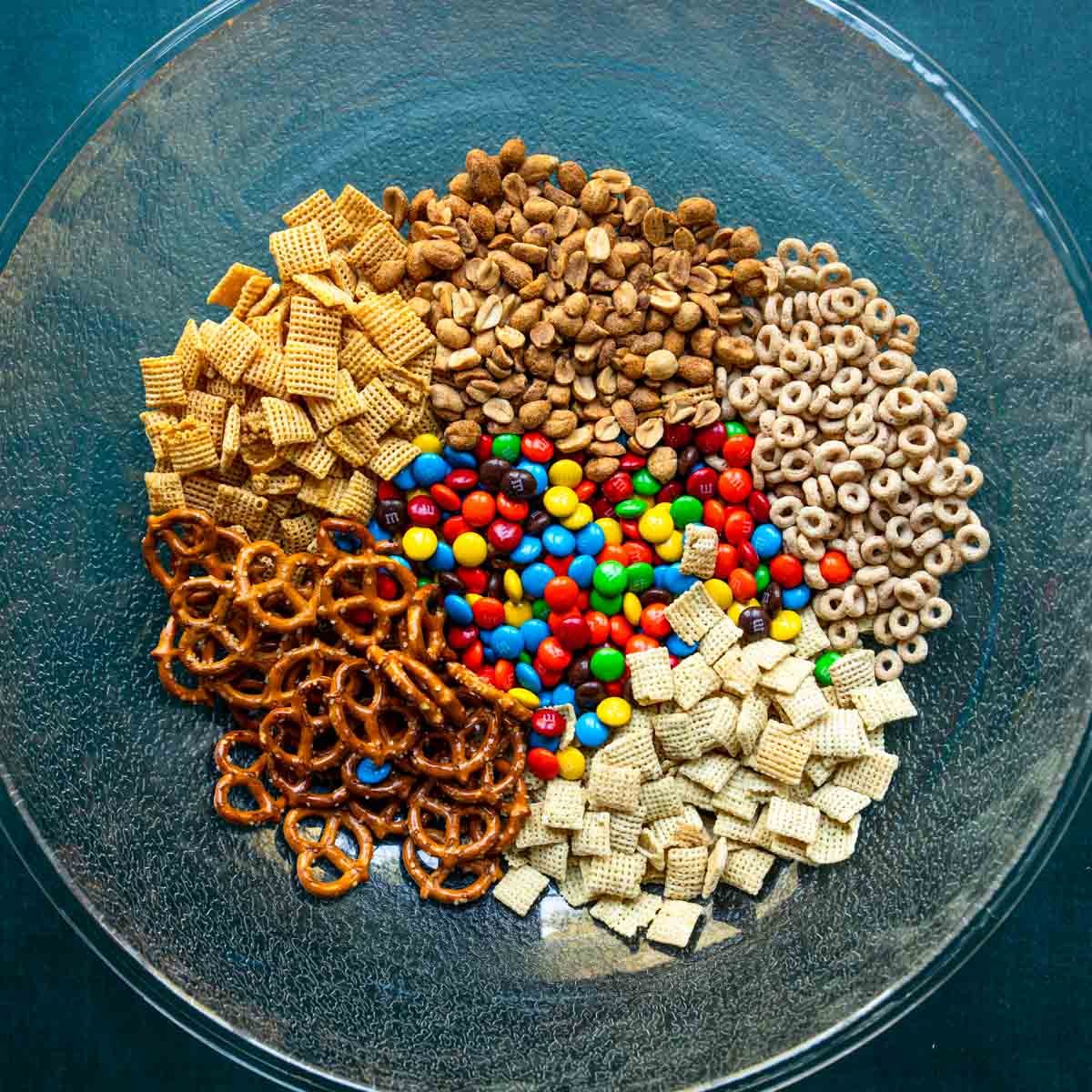 Dry ingredients for white chocolate chex mix measured and added to a mixing bowl but not combined.