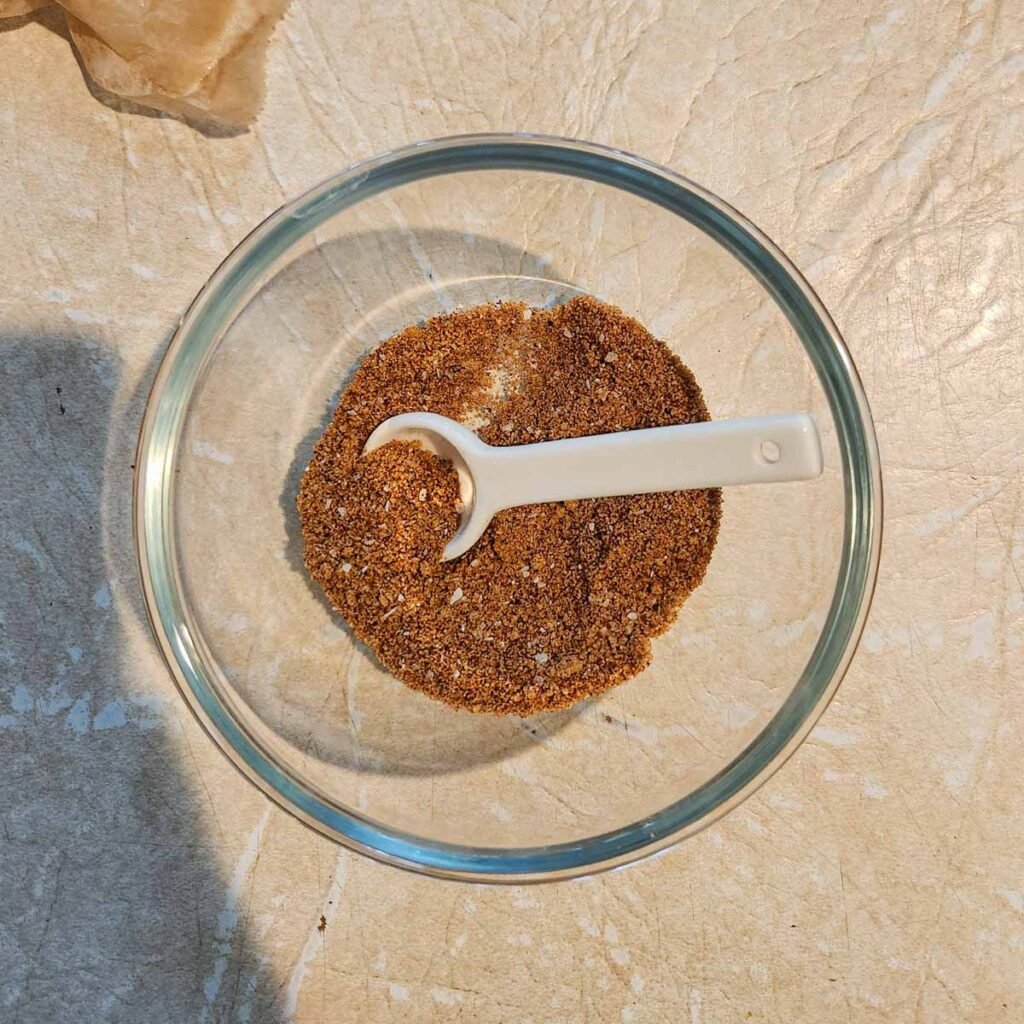 Dry rub in a bowl with a spoon.