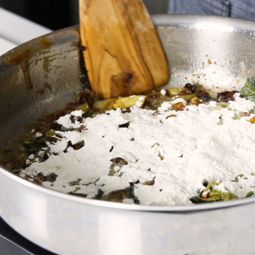 Flour added to the veggie mixture in a skillet.