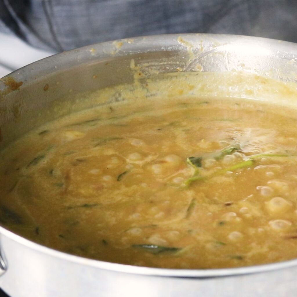 Gravy simmering in a skillet.