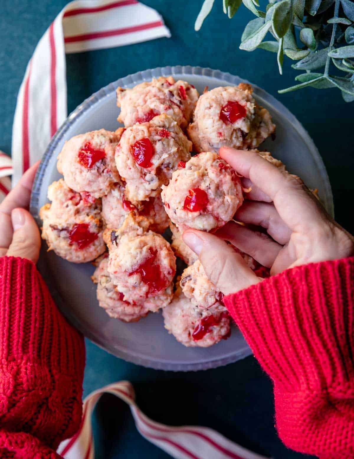 Hand picking up a cherry macaroon.