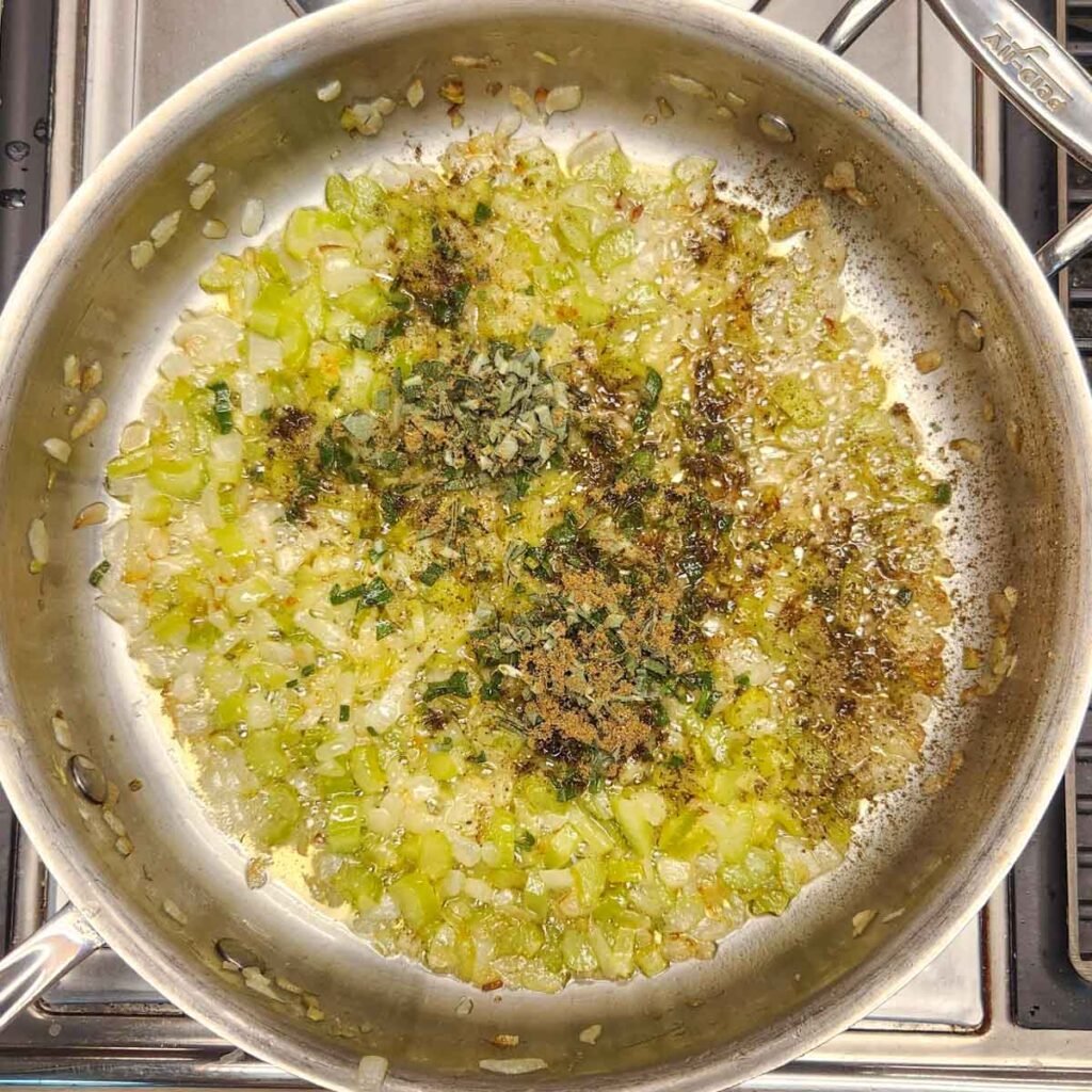 Spices added to the onion mixture in the skillet.