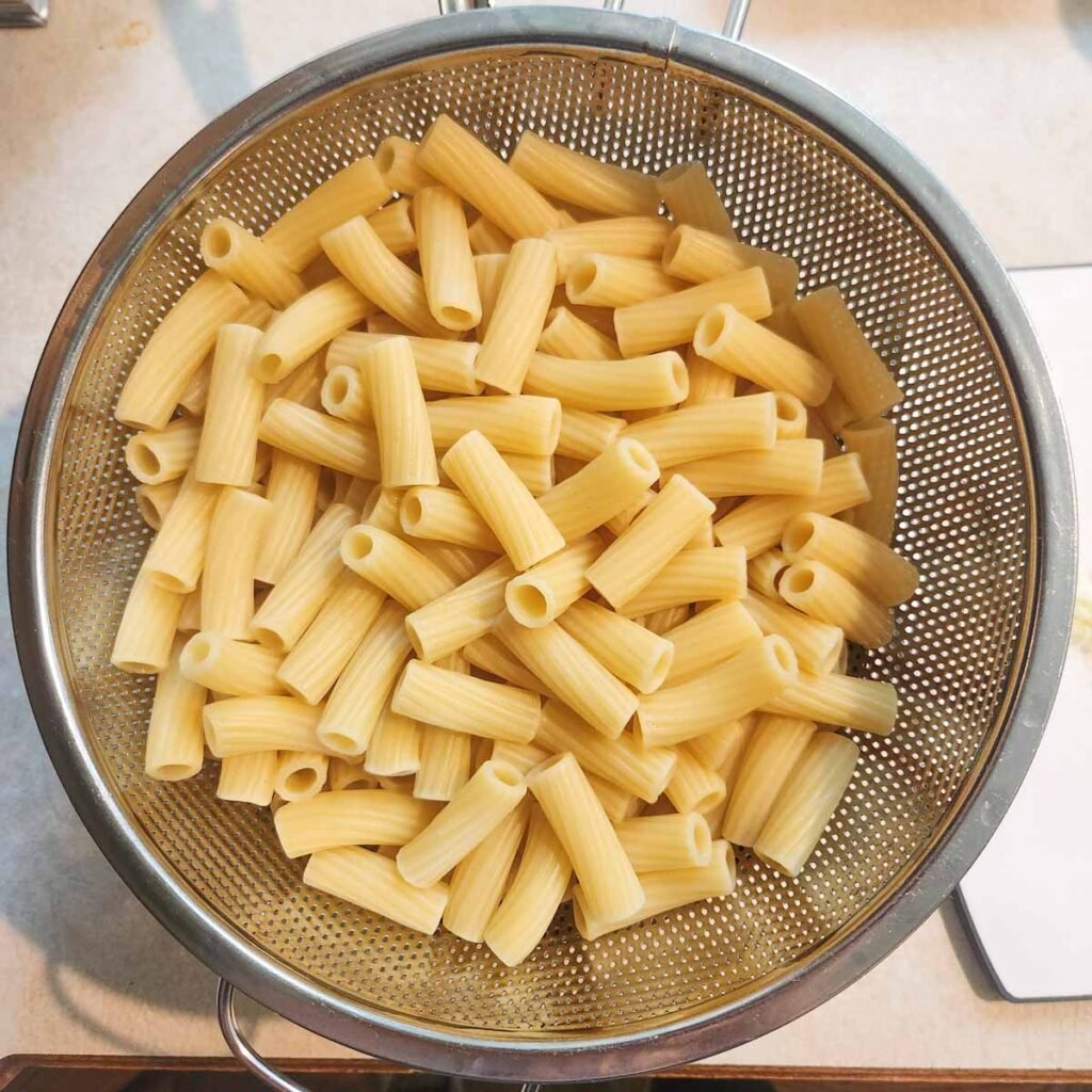 Cooked rigatoni in a colander.