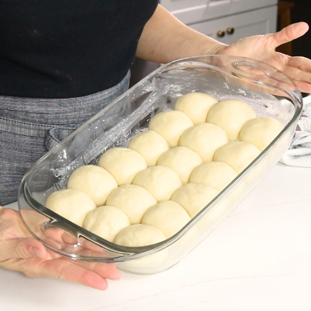 dinner rolls that have risen in a 9x13 pan, ready for the oven