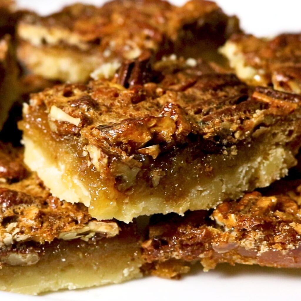 A stack of pecan pie bars that have a shortbread crust