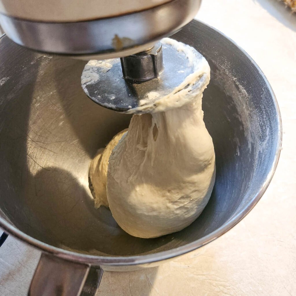 dinner roll dough that is in a stand mixer on a dough hook