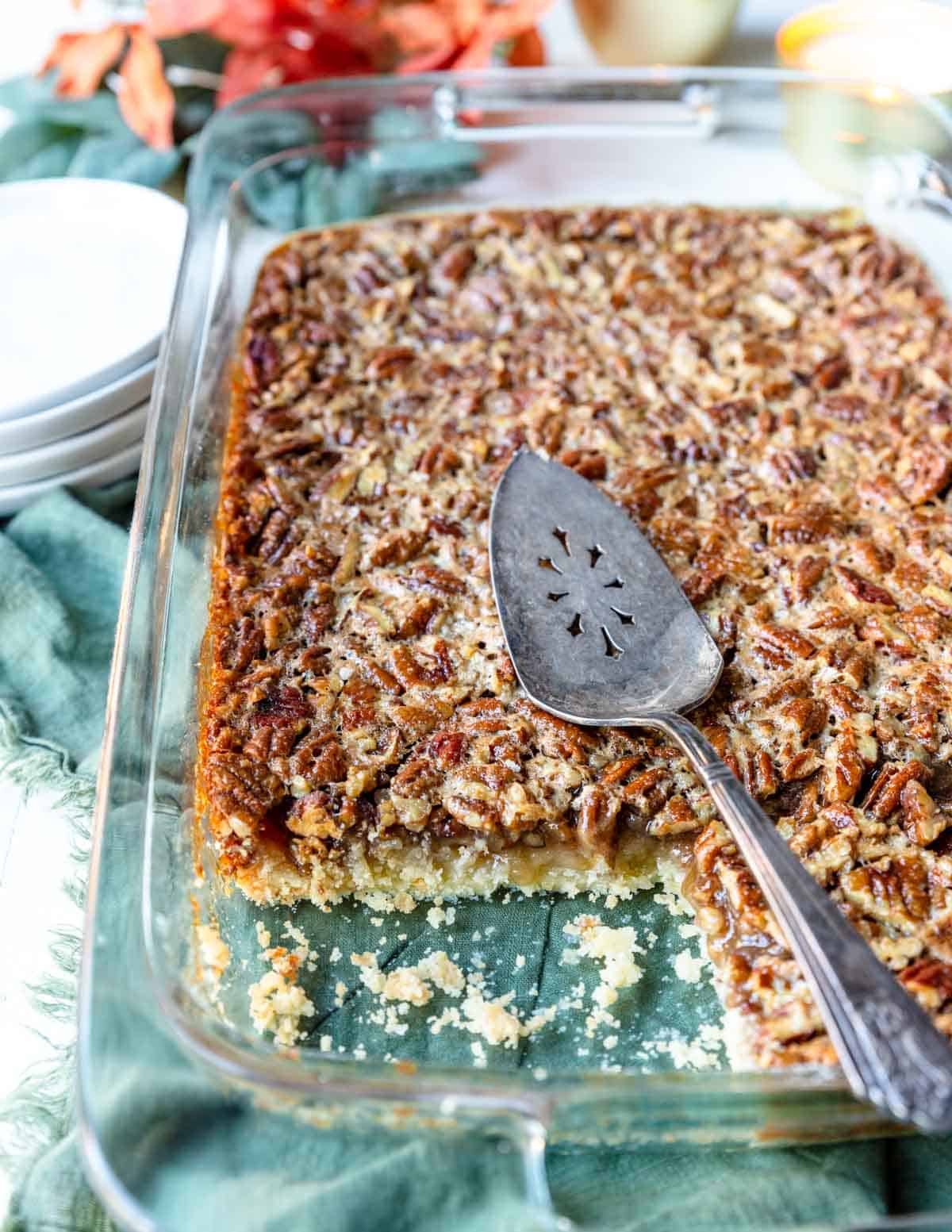 Pecan Pie Bars in a 9x13 pan with a pie server on top 