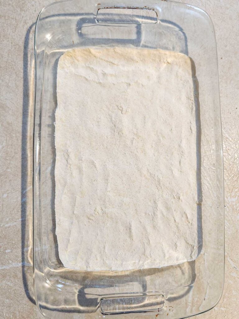 shortbread crust pressed into a 9x13 pan, ready for the oven.