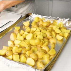 Yukon gold potatoes quartered and placed on a foil covered baking sheet.