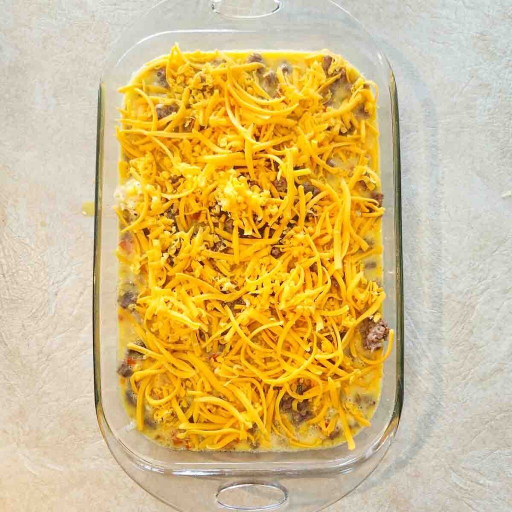 Shredded cheese added to the top of the hashbrown mixture.