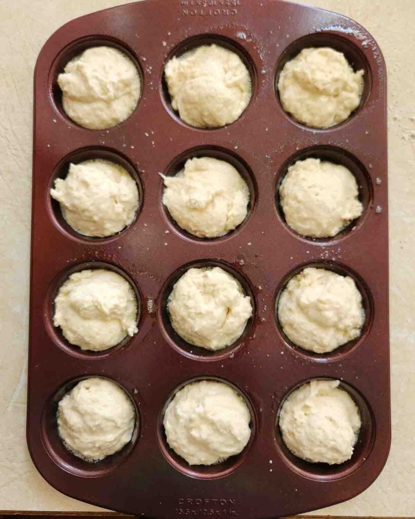 Bisquick biscuit batter added to a muffin tin.