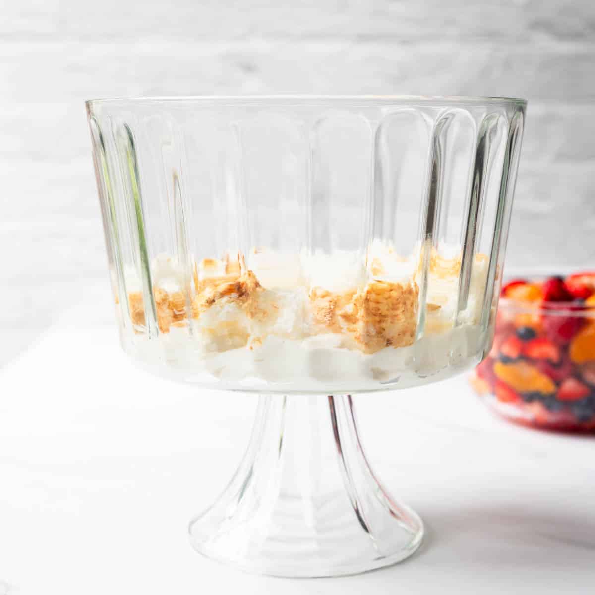 layer of cream and cake in a trifle bowl