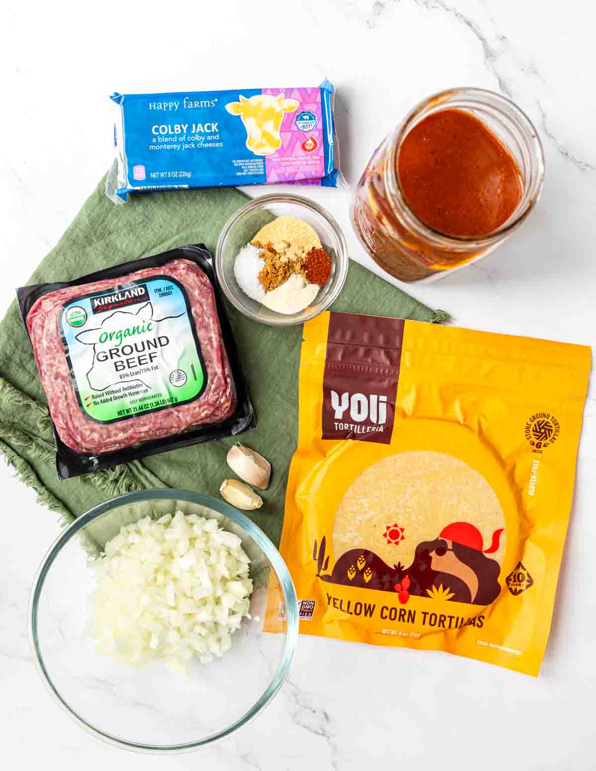 Ingredients shown are used to prepare ground beef enchiladas.