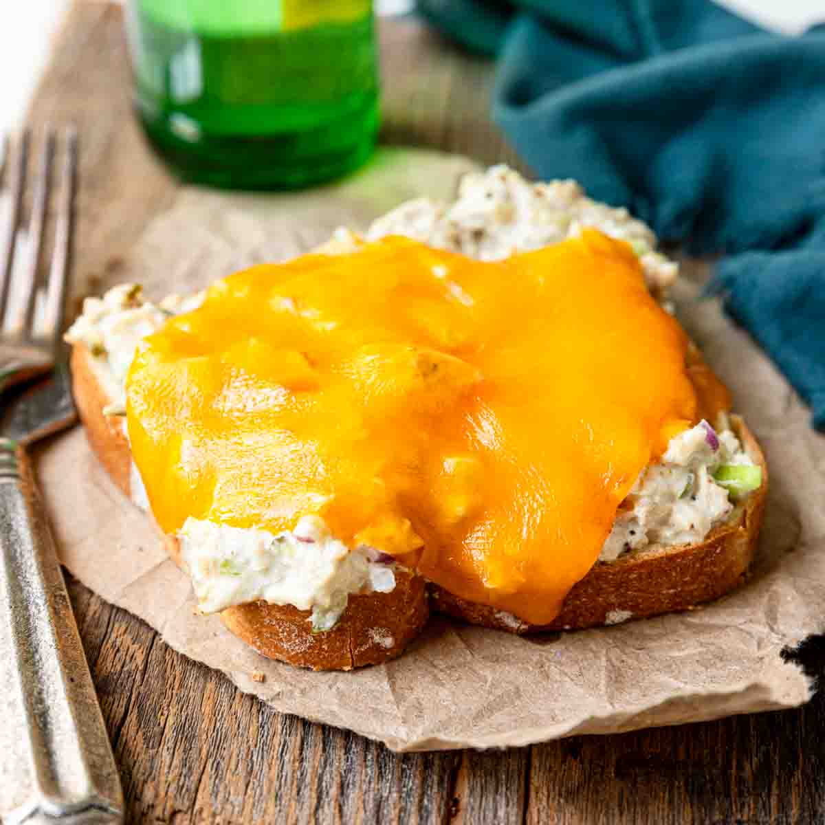 an open faced tuna melt on a piece of parchment paper