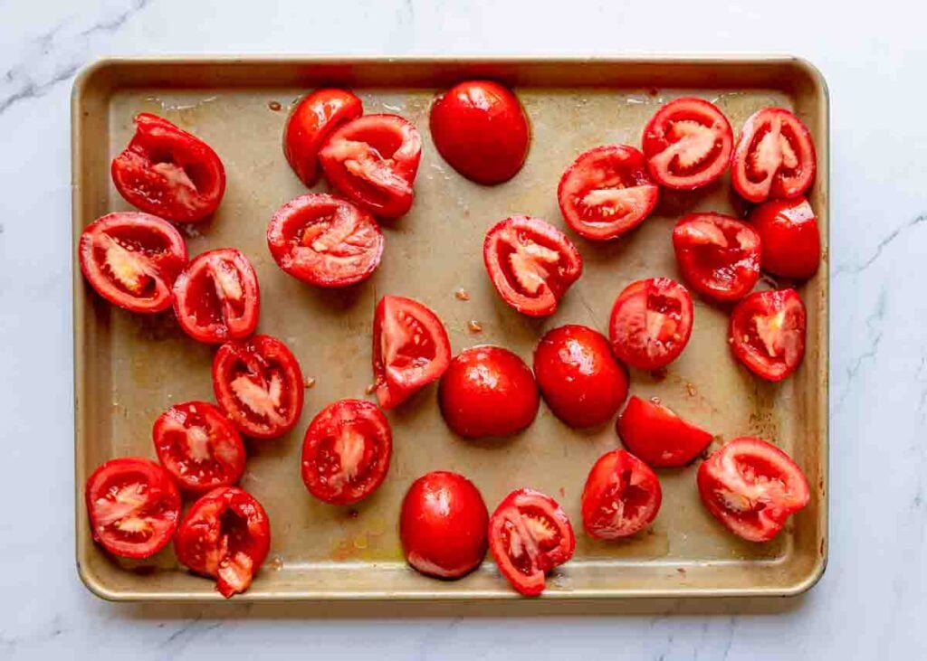 Halved tomatoes on a baking sheet.